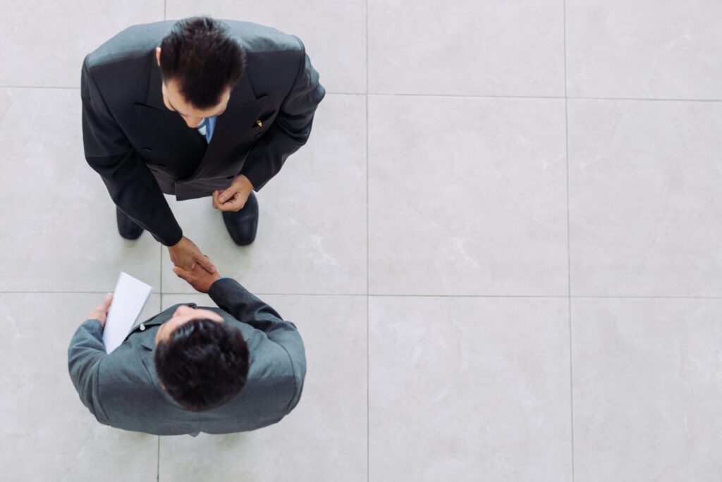 Two men shaking hands from above