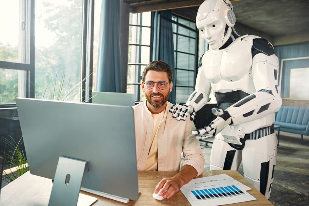 image shows a man at a computer with an AI robot consulting him